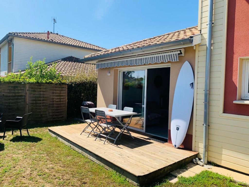 une terrasse avec une table et une planche de surf sur celle-ci, dans l'établissement Charming Quiet House in Soorts Hossegor - Pedebert Area -- Certified 3 stars Holiday Home, à Soorts-Hossegor