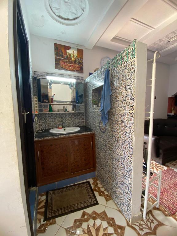 a bathroom with a sink and a mirror at Maison Entière Reposante à 5km de Oualidia in El Akarta