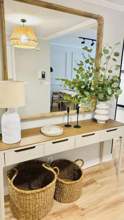 a bathroom vanity with a large mirror and baskets at Piso Porta do Sol in Ribeira