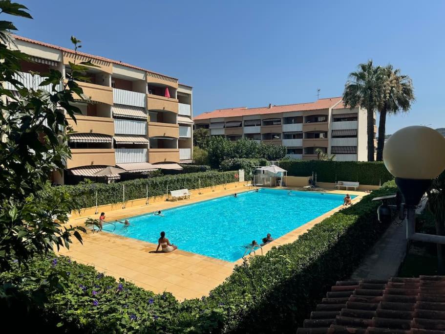 une grande piscine devant un immeuble dans l'établissement Appart proche plage, piscine, clim, parking privé - arrivée autonome - lit queen size, à La Seyne-sur-Mer