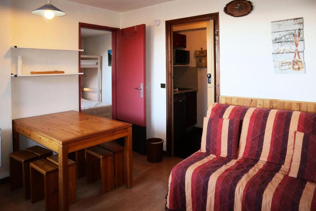 Cette chambre comprend une table, un lit, une table et un banc. dans l'établissement Résidence Le Cairn - STUDIO N° 0311 LE CAIRN MAE-4521, aux Orres