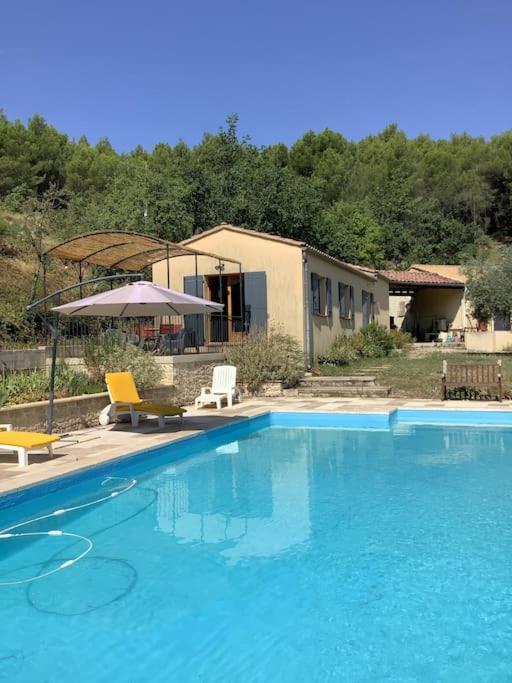 une piscine avec deux chaises et une maison dans l'établissement Maison du vallon de Galeye, à La Roque-sur-Pernes