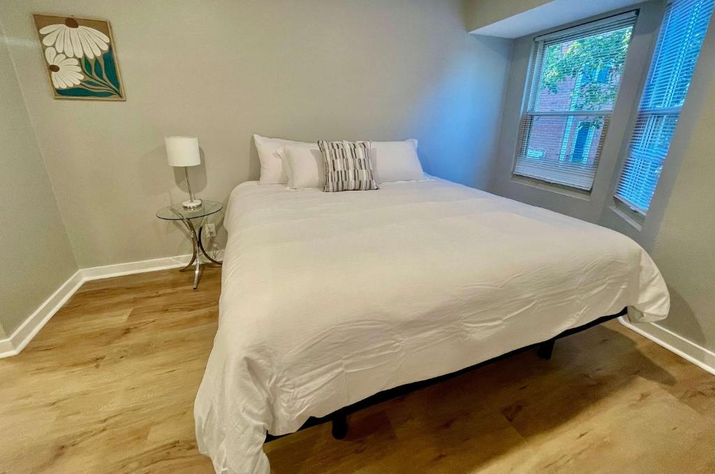 ein Schlafzimmer mit einem Bett mit weißen Laken und einem Fenster in der Unterkunft Aksarben Modern 1Bed ground level with parking in Omaha