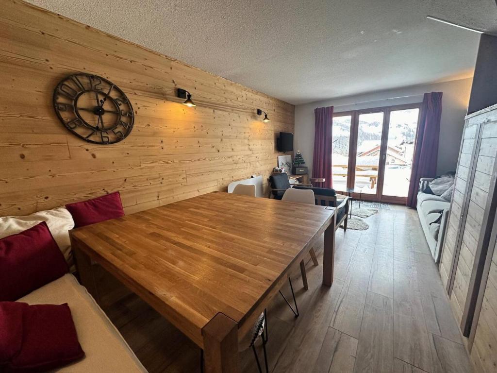 - un salon avec une table en bois et une horloge murale dans l'établissement Résidence Le Bouquetin Ii - LE BOUQUETIN II MAE-9961, à Vars