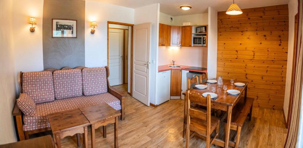 un salon avec une table et un canapé et une cuisine dans l'établissement Résidence Les Hauts De Preclaux - 2 pièces pour 6 personnes aux Orres 1800 MAE-1751, aux Orres
