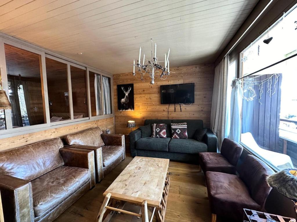 ein Wohnzimmer mit Ledersofas und einem Tisch in der Unterkunft Résidence Les Ecrins 1 - RESIDENCE LES ECRINS 1 MAE-0421 in Vars
