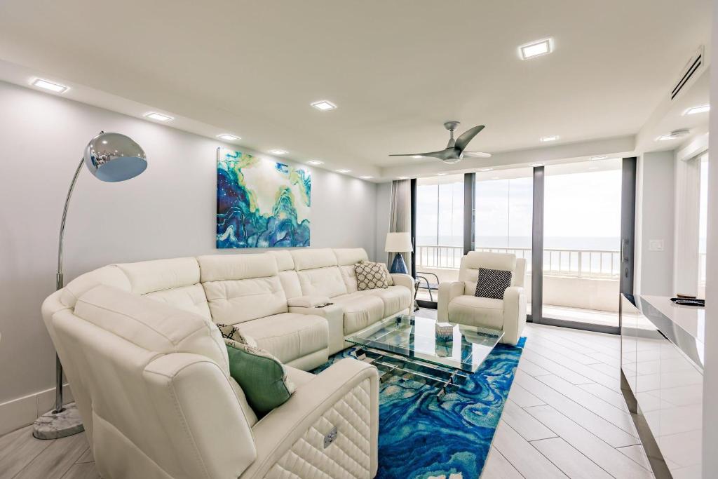 een woonkamer met witte meubels en een blauw tapijt bij 2 BR Condo by the Beach - Splendid Ocean View in Marco Island