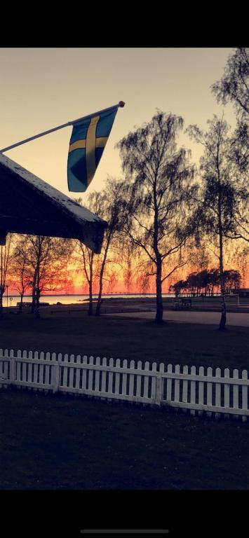 a kite flying over a fence with trees in the background at Ölandspärlan 2 in Färjestaden