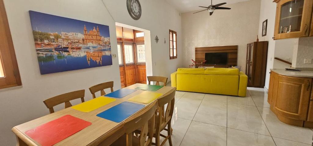 a dining room with a table and a yellow couch at Villa on Sliema Promenade and ferries in Sliema