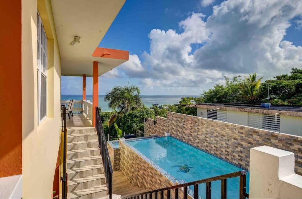 una vista sulla piscina dal balcone di una casa di Villa Marbella - Ocean Views & Private Pool a Luquillo