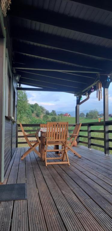 a picnic table and bench on a wooden deck at Magura Rustic Tiny House in Măgura