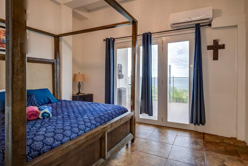 - une chambre avec un lit et une croix sur le mur dans l'établissement 2 Ocean View Villas with Private Pool, à Luquillo