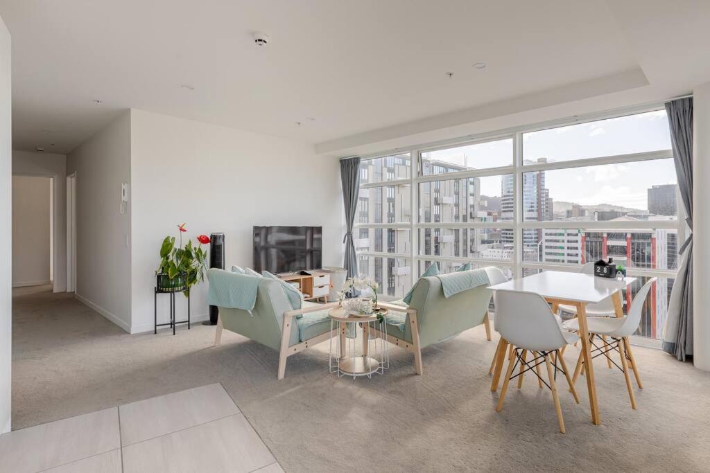 a living room with a table and chairs and a large window at Harbor View Two Bedroom Apartment At Pinnacle in Wellington