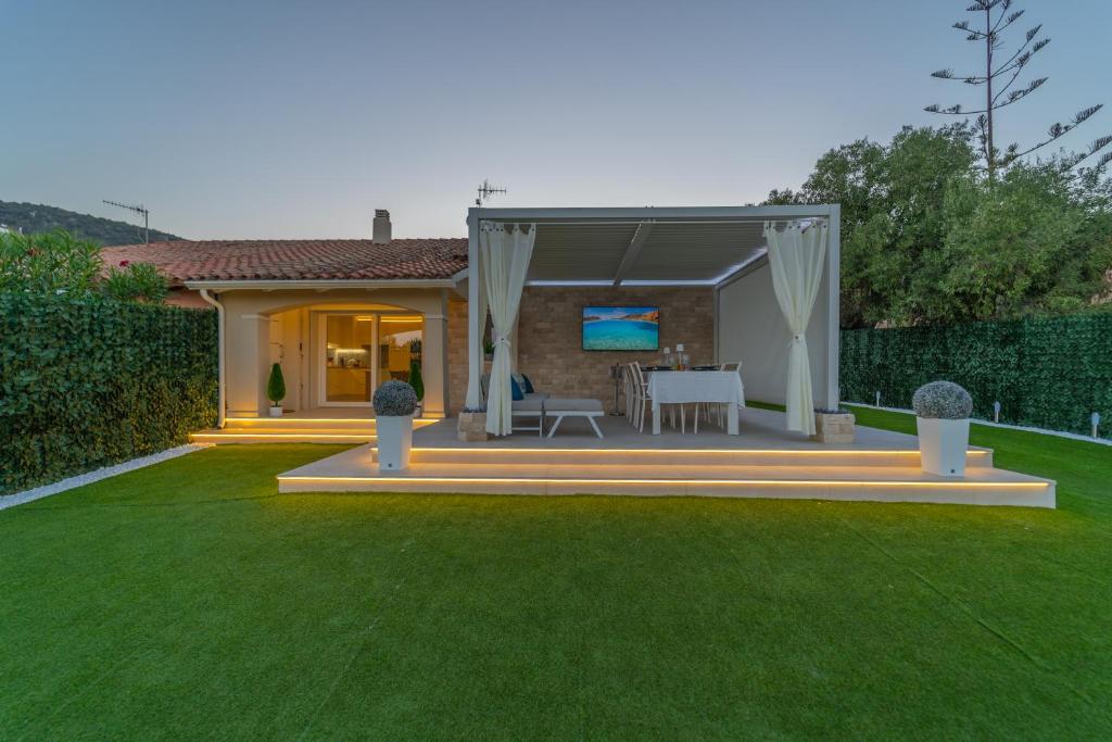 a patio with a table and a television in a backyard at Villa Vittorio in San Teodoro