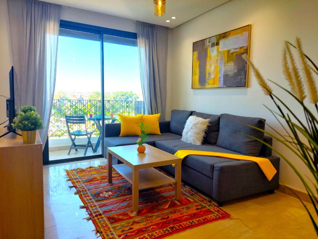 ein Wohnzimmer mit einem blauen Sofa und einem Tisch in der Unterkunft Welcome Home Palmiers in Casablanca