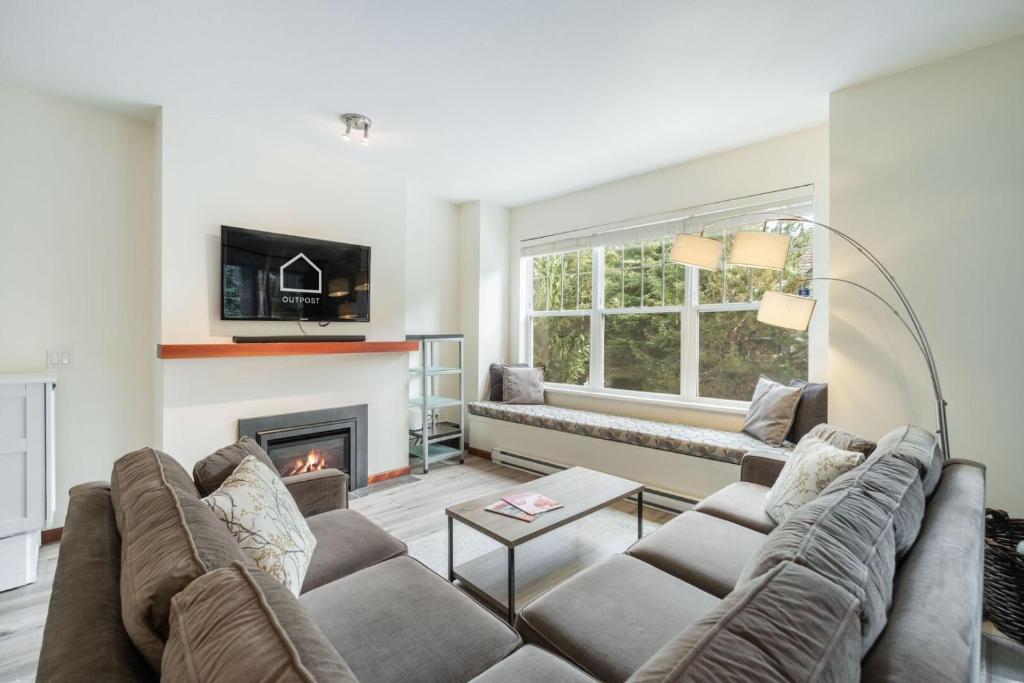 a living room with a couch and a fireplace at Deer Run by Outpost Whistler in Whistler