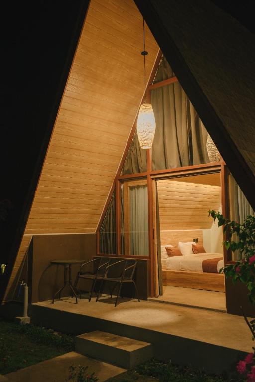 a room with a bed and a table and chairs at Maya Ocean Resort in Selong Belanak