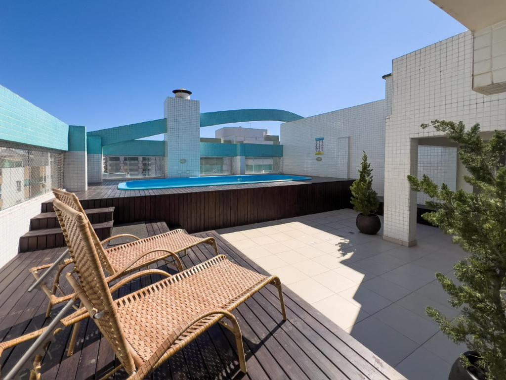 a patio with two chairs and a swimming pool at Piscina, churrasqueira, garagem, sauna e academia! in Capão da Canoa
