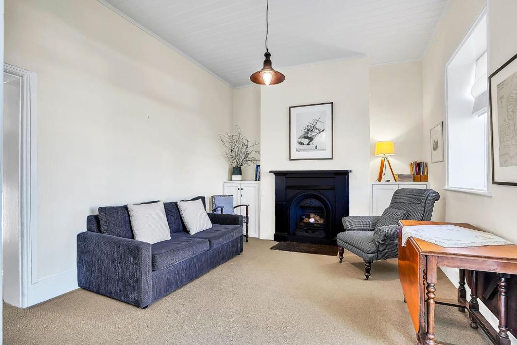 un soggiorno con divano e camino di Cottage on James circa 1855 a Port Fairy
