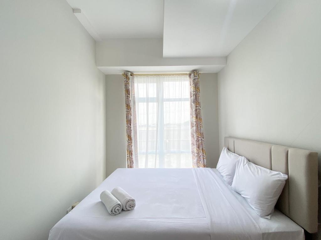 Кровать или кровати в номере Cozy Stay 1BR at Vasanta Innopark Apartment By Travelio