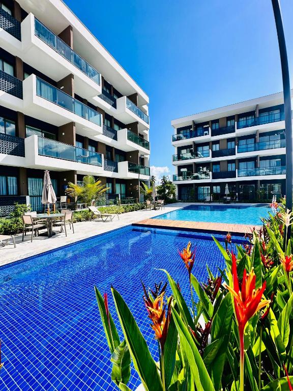 a swimming pool in front of a building at Makia Beach Experience # Flat Térreo B-019 in Porto De Galinhas