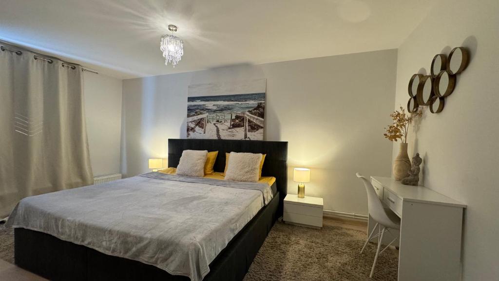 een slaapkamer met een bed en een bureau erin bij Elite Residence in Timişoara