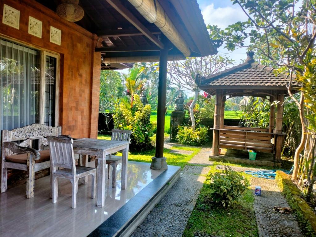 un patio con tavolo e sedie in una casa di Villa Poleng ad Ubud