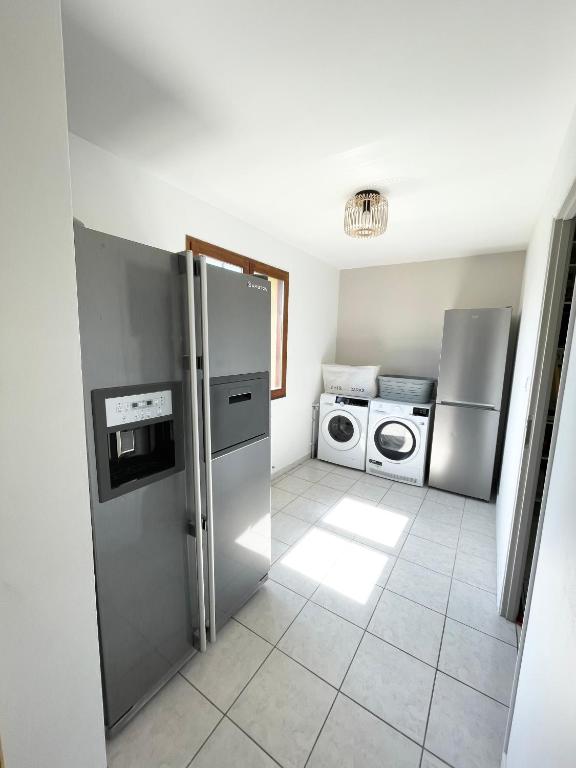 d'une cuisine équipée d'un réfrigérateur en acier inoxydable et d'un lave-linge. dans l'établissement Vacation home in Etaples - near to Le Touquet, à Étaples