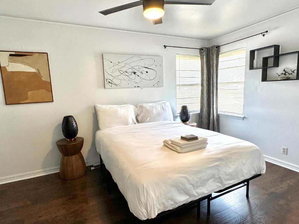 a bedroom with a large white bed with a ceiling fan at 1BR Apt 7 mins Integris Children's Laundry in Oklahoma City
