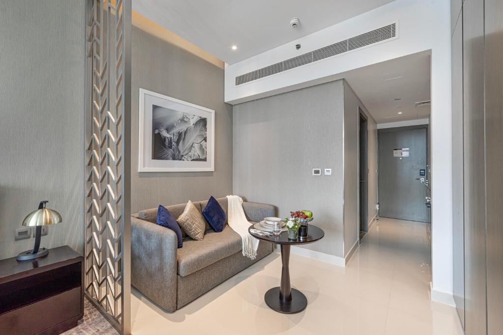 a living room with a couch and a table at Livin' Holidays - Luxury studio with Bay view in Dubai