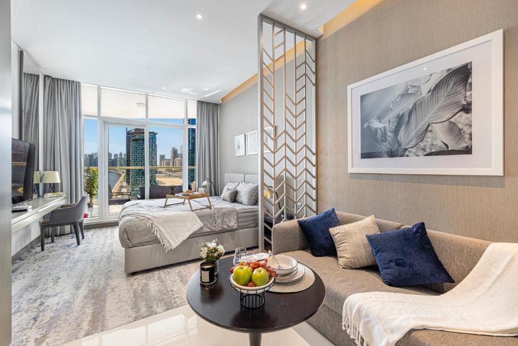 a living room with a couch and a bed at Livin' Holidays - Luxury studio with Bay view in Dubai