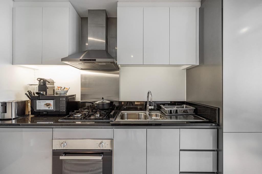 a kitchen with a sink and a microwave at Livin' Holidays - Luxury studio with Bay view in Dubai