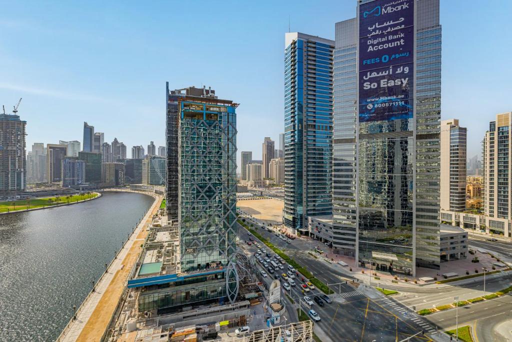 a view of a city with tall buildings and a river at Livin' Holidays - Luxury studio with Bay view in Dubai
