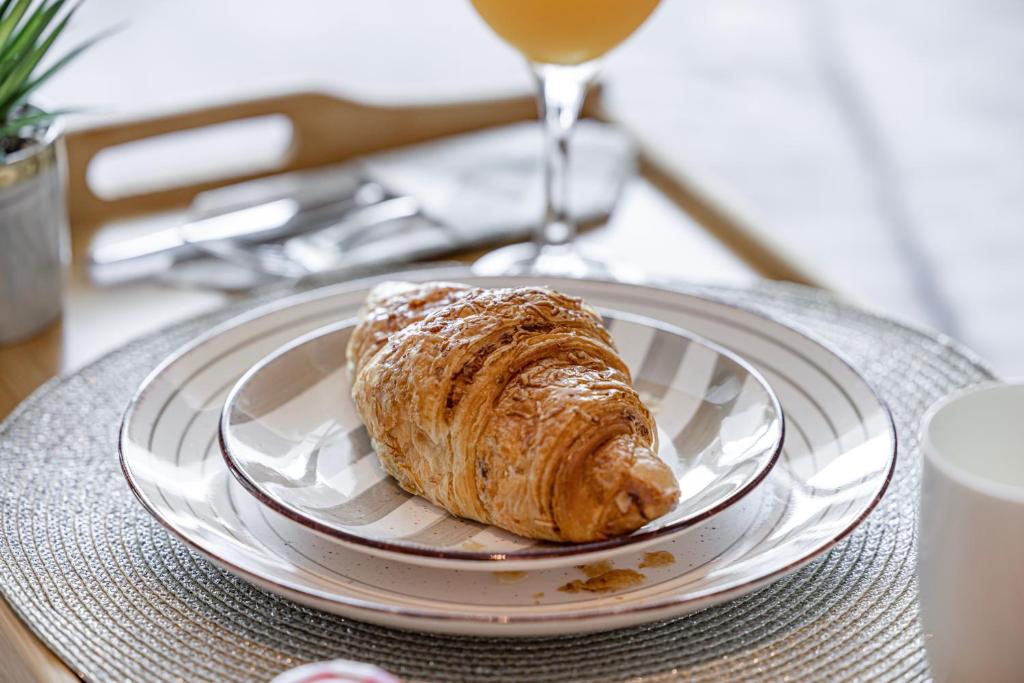 a pastry on a plate on a table with a glass of wine at Livin' Holidays - Luxury studio with Bay view in Dubai