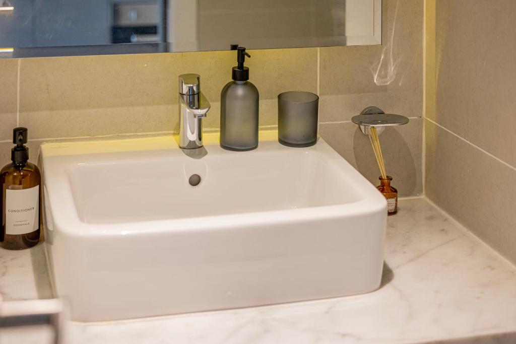 a white sink with two bottles on top of it at Livin' Holidays - Luxury studio with Bay view in Dubai