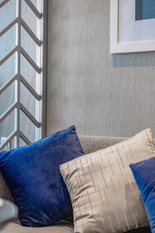 two blue and white pillows sitting on a couch at Livin' Holidays - Luxury studio with Bay view in Dubai