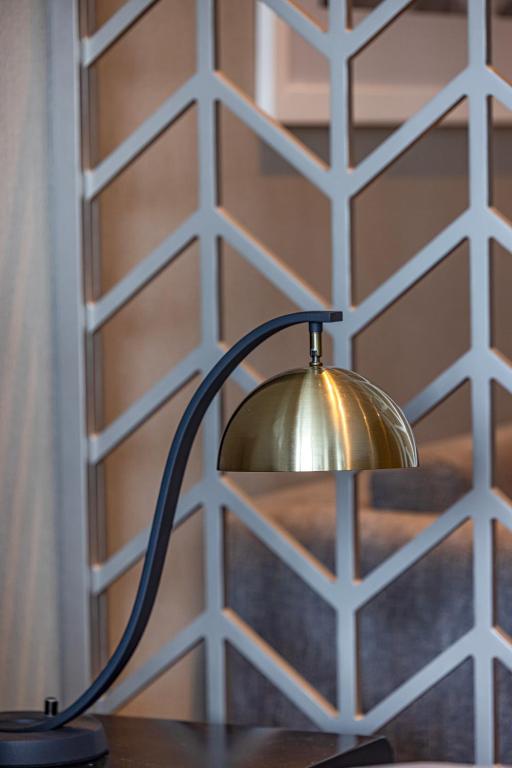 a lamp on a table in front of a wall at Livin' Holidays - Luxury studio with Bay view in Dubai
