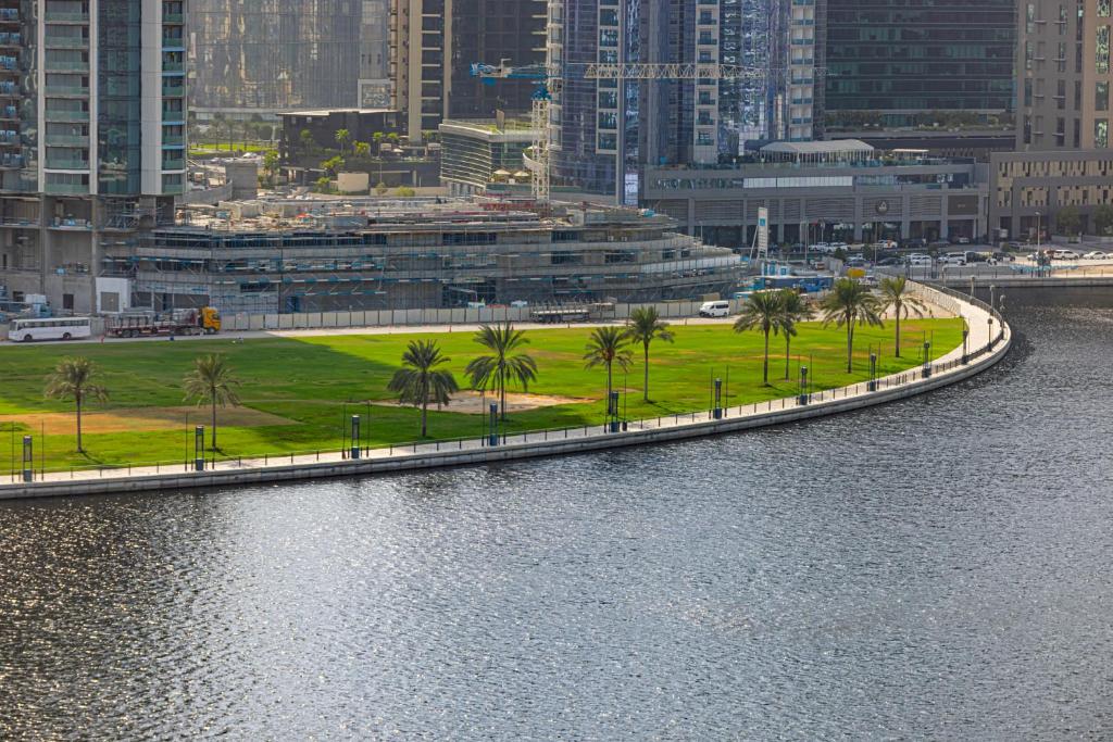 a body of water with palm trees and a city at Livin' Holidays - Luxury studio with Bay view in Dubai