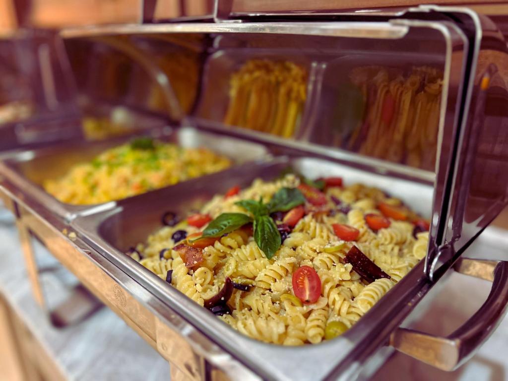 a tray of food with pasta and vegetables at Villa Sirilanna Hotel in Chiang Mai