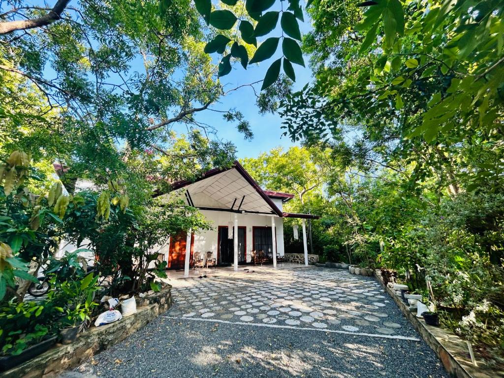 Neem safari lodge Yala في تيساماهاراما: اطلالة خارجية على منزل مع حديقة