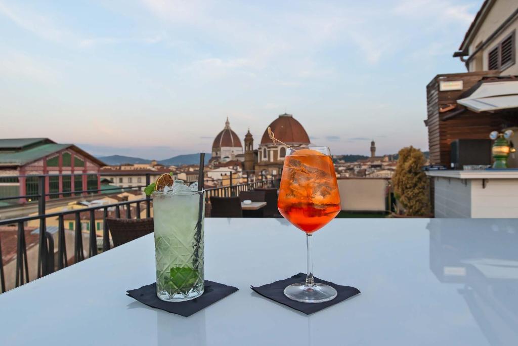 two glasses on a table with a view of a city at Hotel Machiavelli Palace in Florence