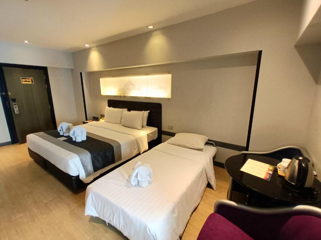 A compact triple room with a double bed, single bed and in-room beverage station.