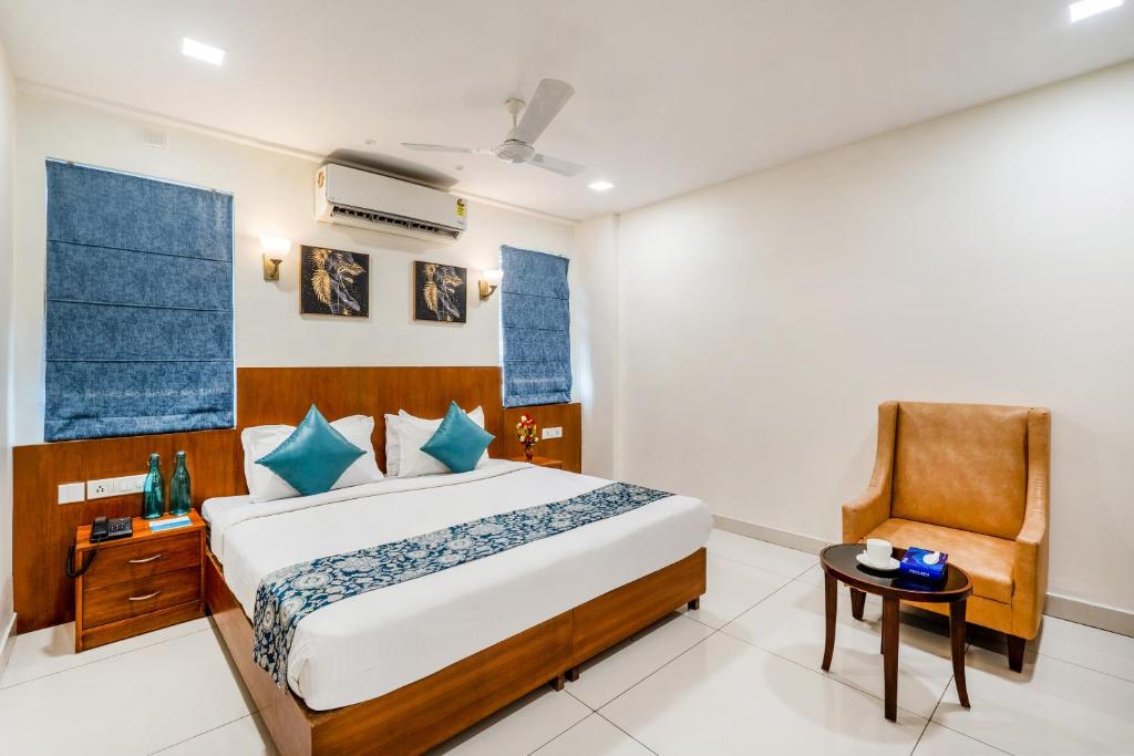 a bedroom with a bed and a chair at WESTSIDE HOTEL HiTECH CITY in Hyderabad