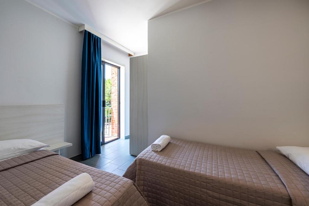 Łóżko lub łóżka w pokoju w obiekcie Hotel La Siesta