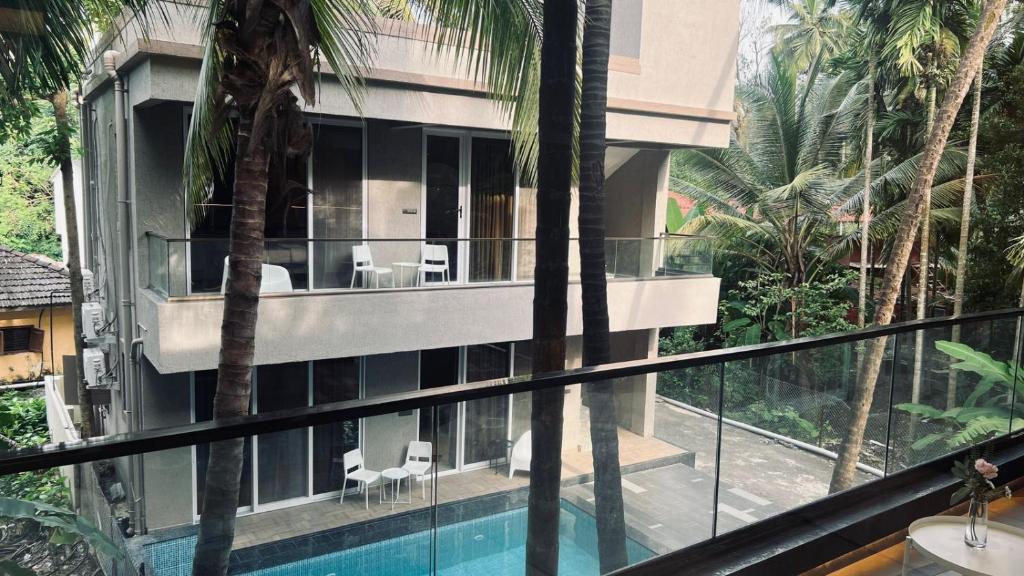 a house with a swimming pool and palm trees at Waves By Jumbo Holidayz in Alibag