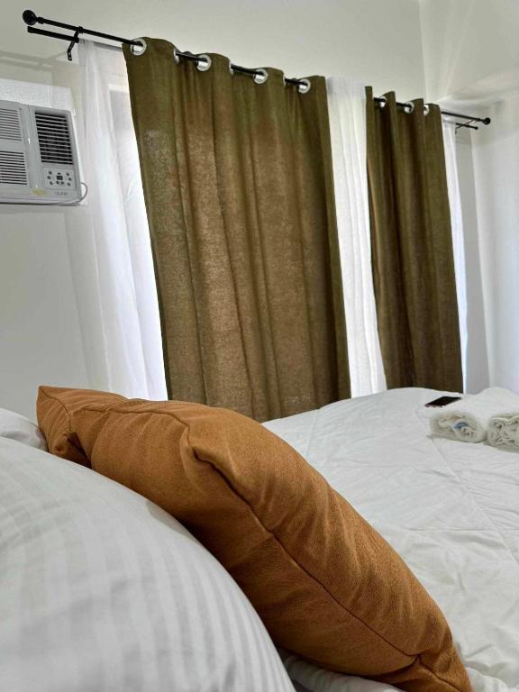 a bed with a pillow sitting on top of it at Amani Grand Citygate in Pampanga
