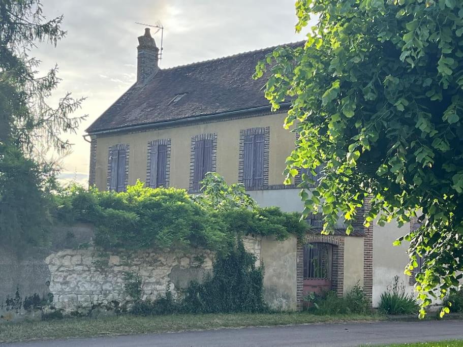 an old white house with a stone wall at Confort et calme à moins de 2h de Paris in Boudernault