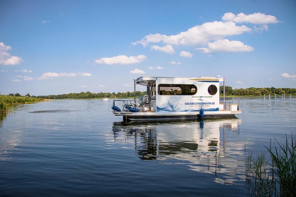 a small boat is docked on a body of water at Hausboot als Festlieger im Hafen -Hafenruhe- in Braunsbedra