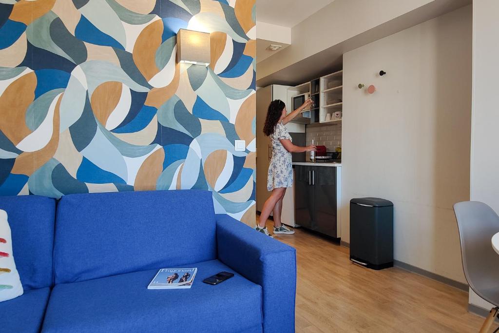 une femme dans un salon en train de peindre un mur dans l'établissement Aparthotel AMMI Nice Massena - ex Ajoupa, à Nice