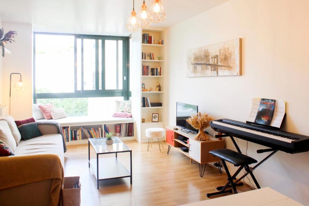 un salon avec un piano et un canapé dans l'établissement 1 bedroom apartment with garden, à Asnières-sur-Seine